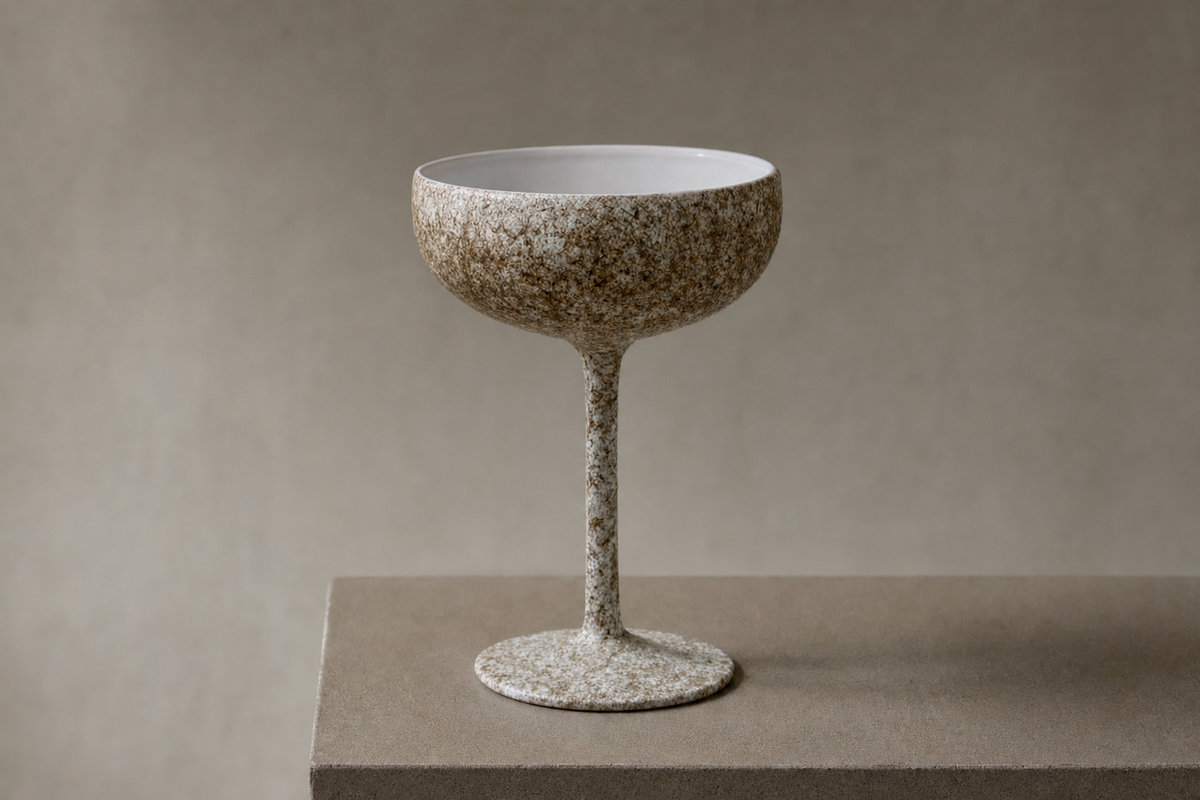 Editorial rendering of a pale Ranshi Urushi champagne saucer on a pedestal