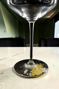 Modern Japan Craftsの梨地仕上げが施された黒いワイングラス。台座には豪華な金箔があしらわれています。