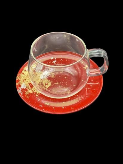 Vermilion gold leaf saucer with a clear glass cup, closer view