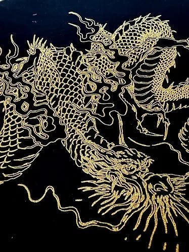 Modern Japan Craftsのジェットブラックの平皿に描かれた、力強い金色の龍の伝統的なデザインのクローズアップ
