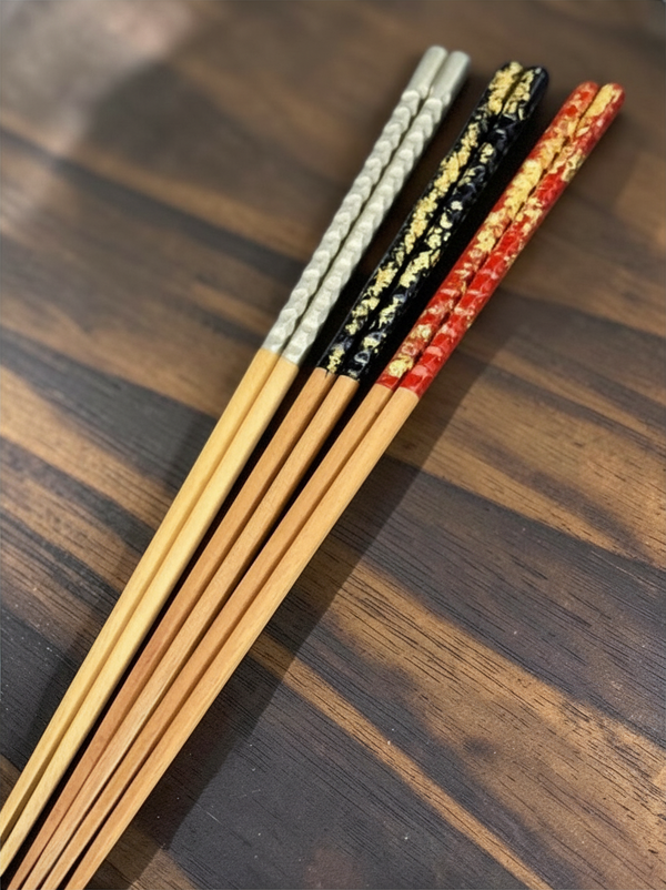 Modern Japan Crafts long chopsticks with white, black, and red lacquer handles featuring gold leaf accents.